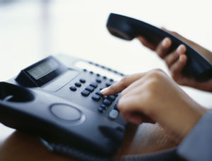 person using a landline phone in an office